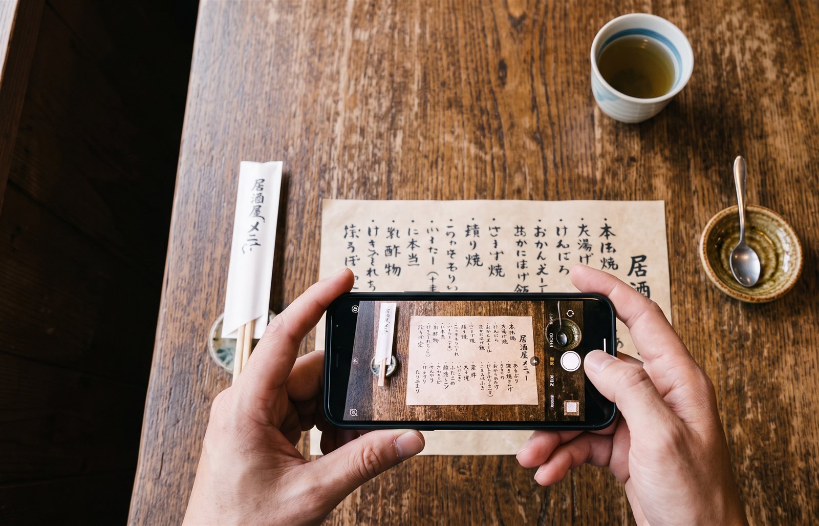 メニュー表をスマートフォンで撮影する手元